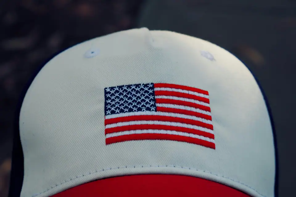 A white and red cap with an embroidered American flag patch